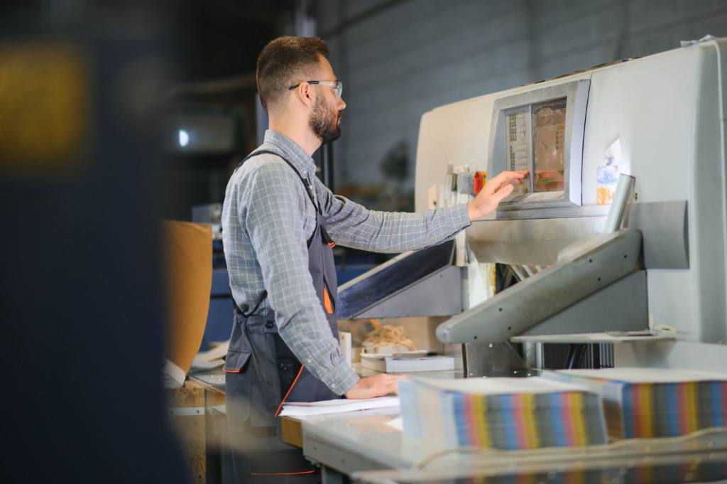 man-operates-machine-in-printing-factory-2026-09-22-03-12-28-utc