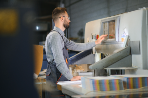 man-operates-machine-in-printing-factory-2026-09-22-03-12-28-utc